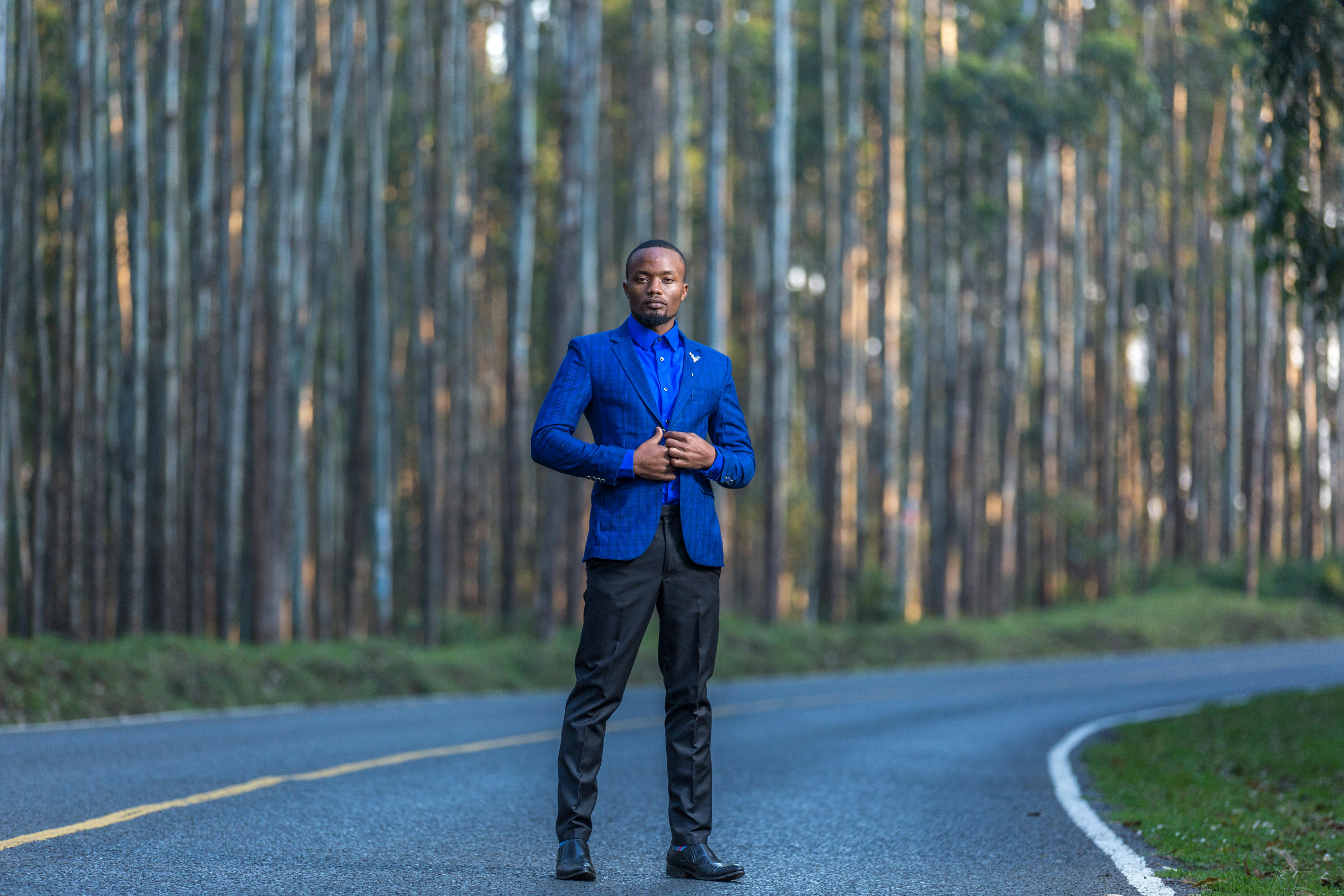 man in suit posing on road outdoors