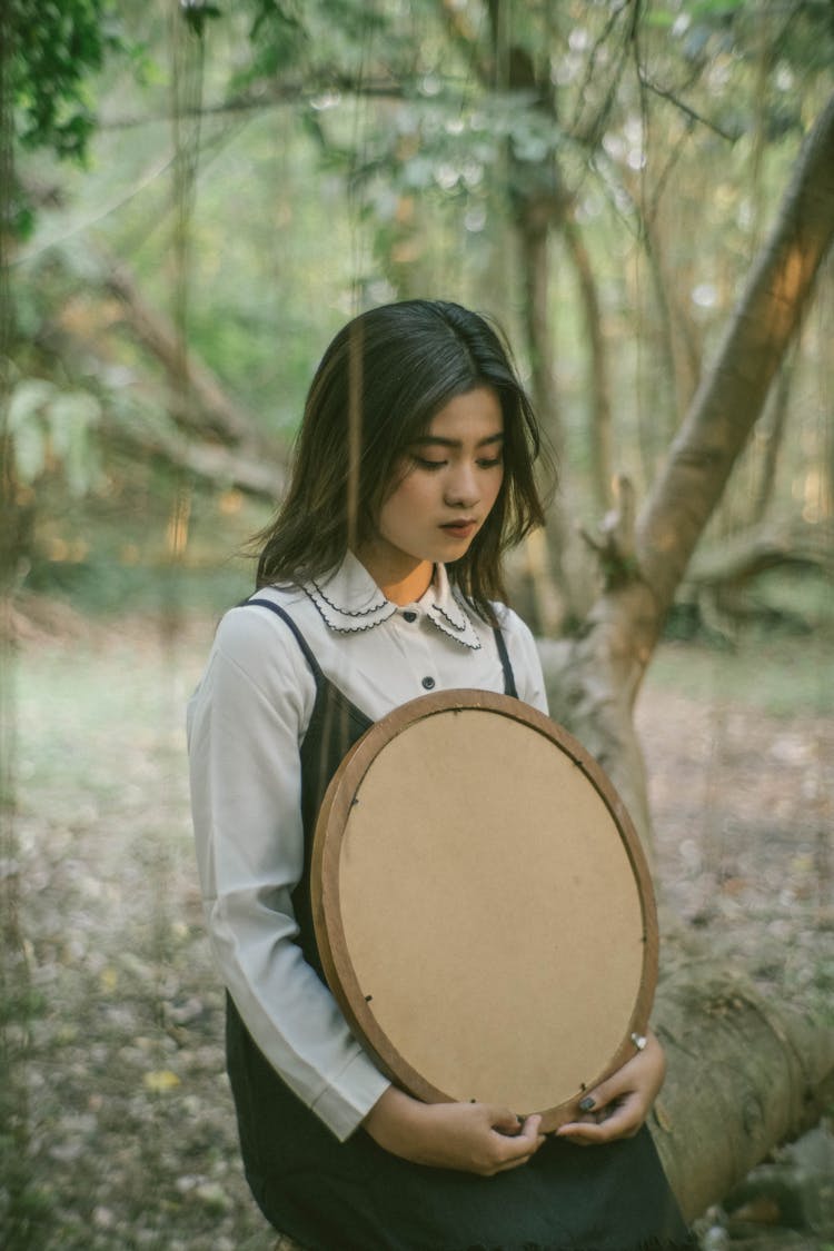 Portrait Of A Girl In A Forest Holding A Round Frame