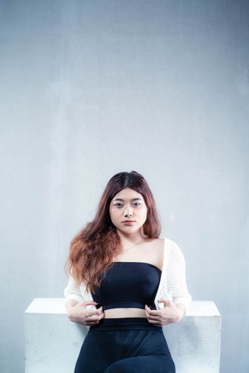 Free A confident woman posing with a minimalist background, showcasing modern fashion. Stock Photo