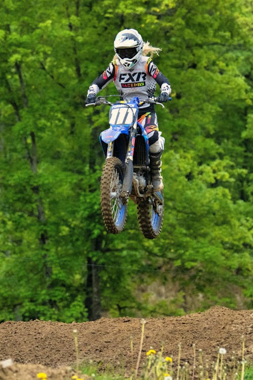 Free Man in Blue and White Motocross Helmet Riding Motocross Dirt Bike Stock Photo