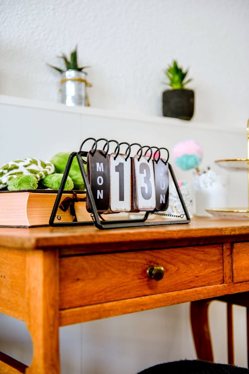 A Metal Perpetual Calendar on Top of a Wooden Drawer