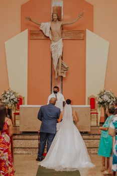 Bride and groom during a wedding ceremony at a Catholic church in Teófilo Otoni, Brazil.