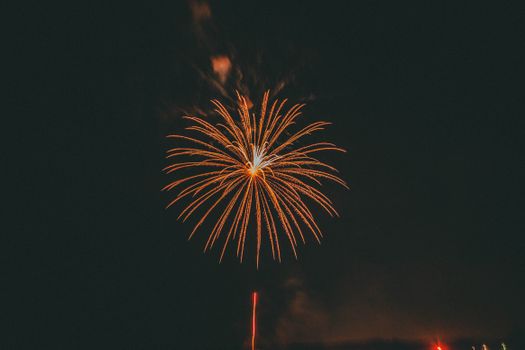 Vibrant fireworks exploding in the dark night sky over Conway, Arkansas.