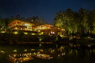 夜晚湖畔的现代房屋令人惊叹，树木倒影在明亮的灯光下