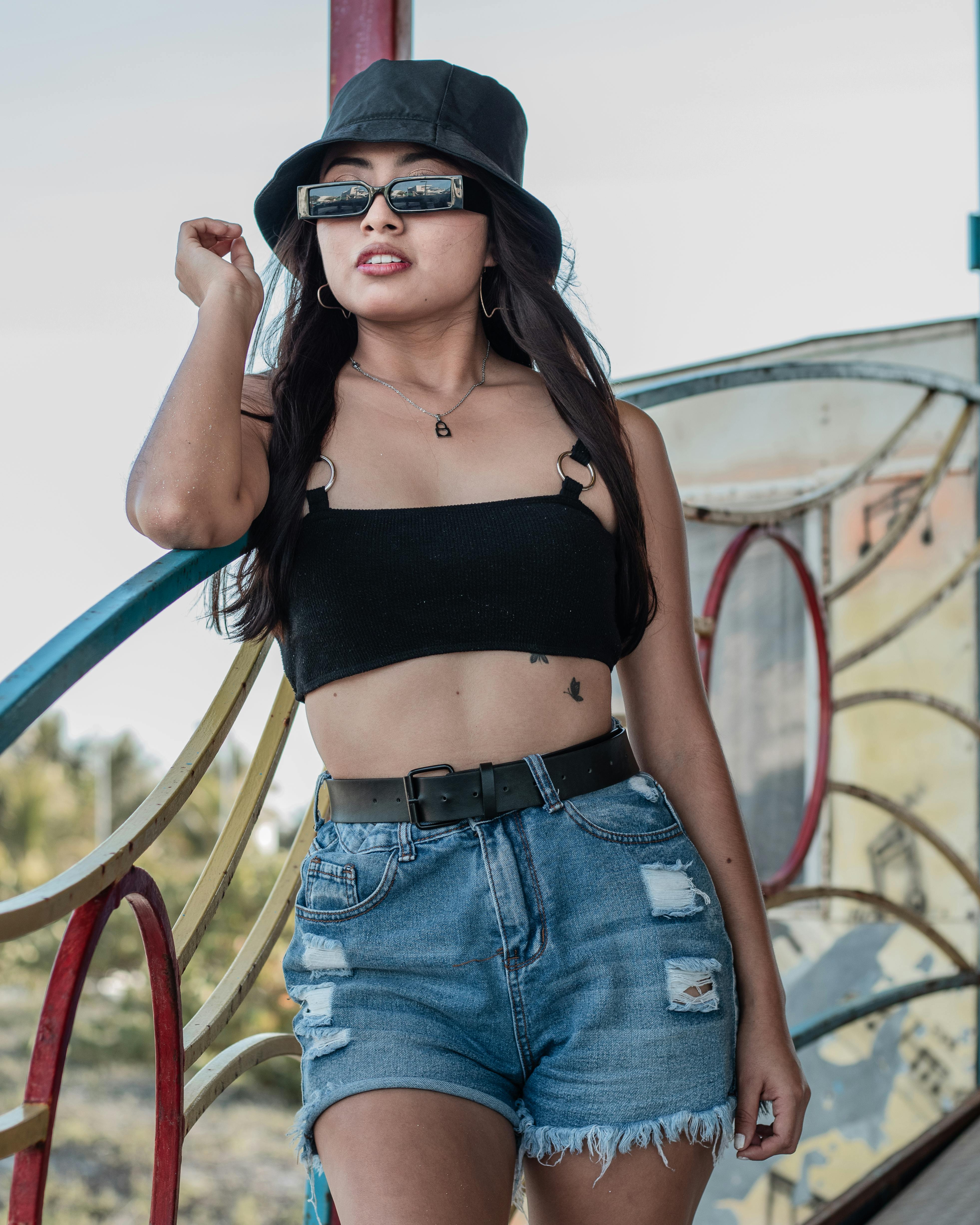 woman wearing a black crop top and denim pants