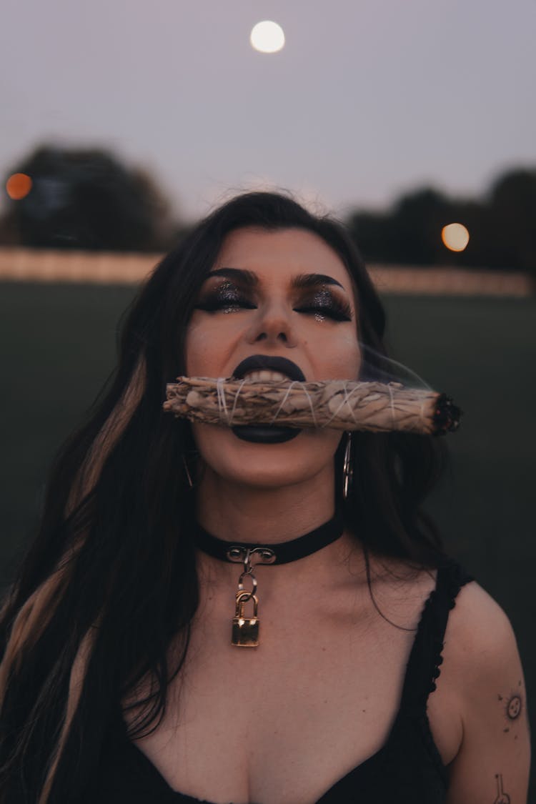 Woman Biting A Burning Sage