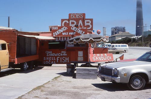 Photo of a Red Food Truck Serving Crabs, Fishes and Sandwiches