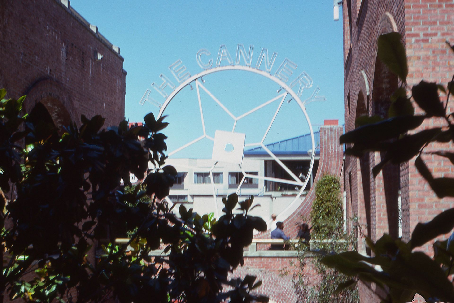 Brick alleyway featuring The Cannery sign in a vibrant city setting.