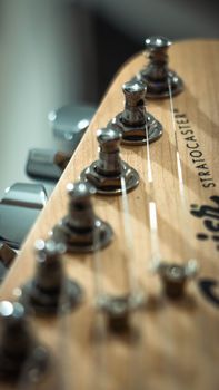Detailed view of a guitar headstock with tuning pegs and strings.