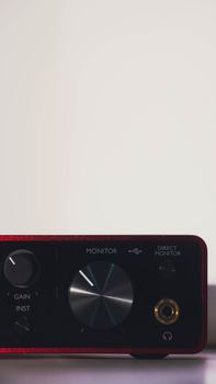 A sleek red audio interface with control knobs, perfect for studio setups.