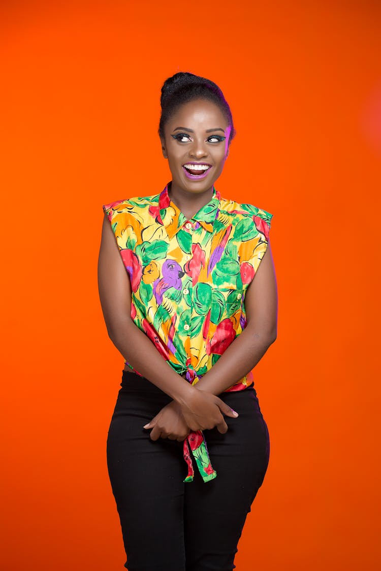 Smiling Woman In Colorful Shirt Standing On Orange 