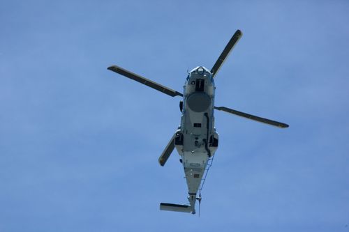 Free A helicopter in flight against a bright blue sky, showcasing aviation dynamics. Stock Photo