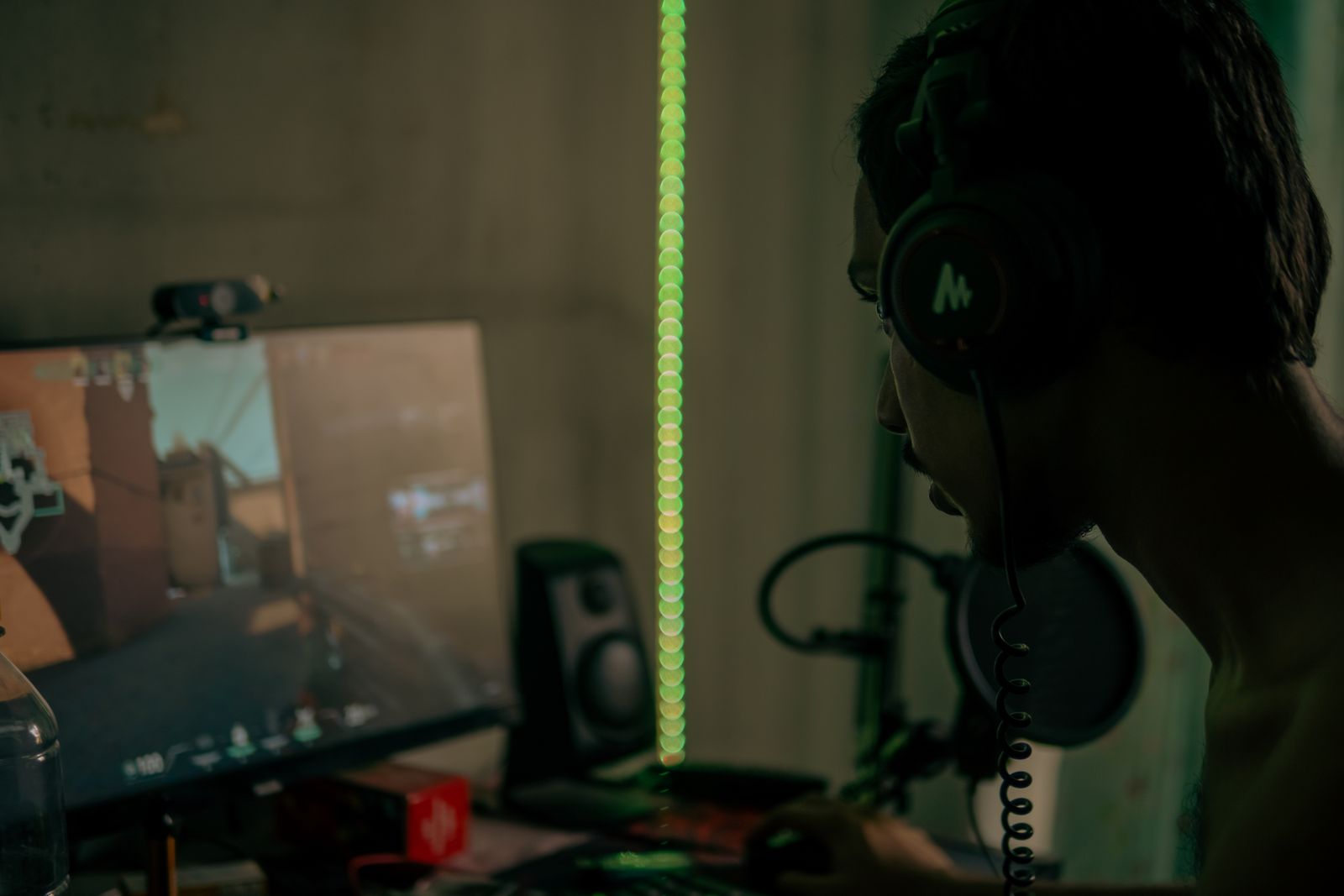 Player wearing a headset while using a gaming computer and keyboard
