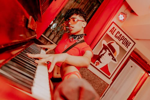 Man in a Red Crop Top Playing the Piano