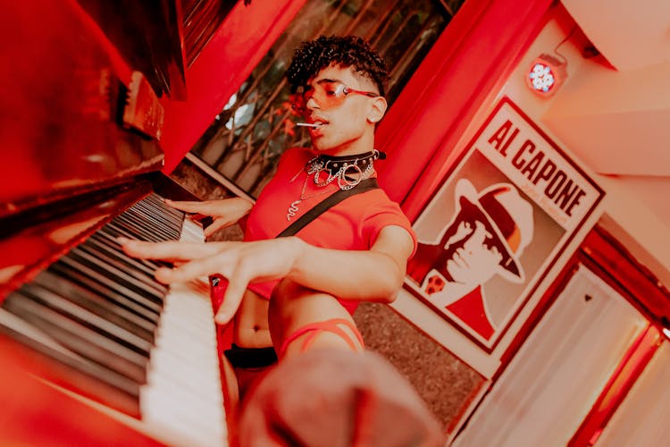 Man In A Red Crop Top Playing The Piano