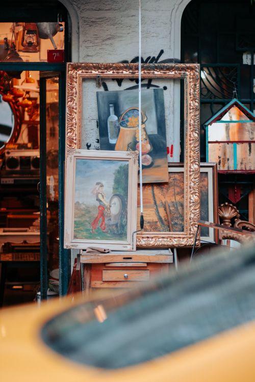 Free Explore an assortment of vintage paintings and frames displayed in a charming antique shop setting. Stock Photo