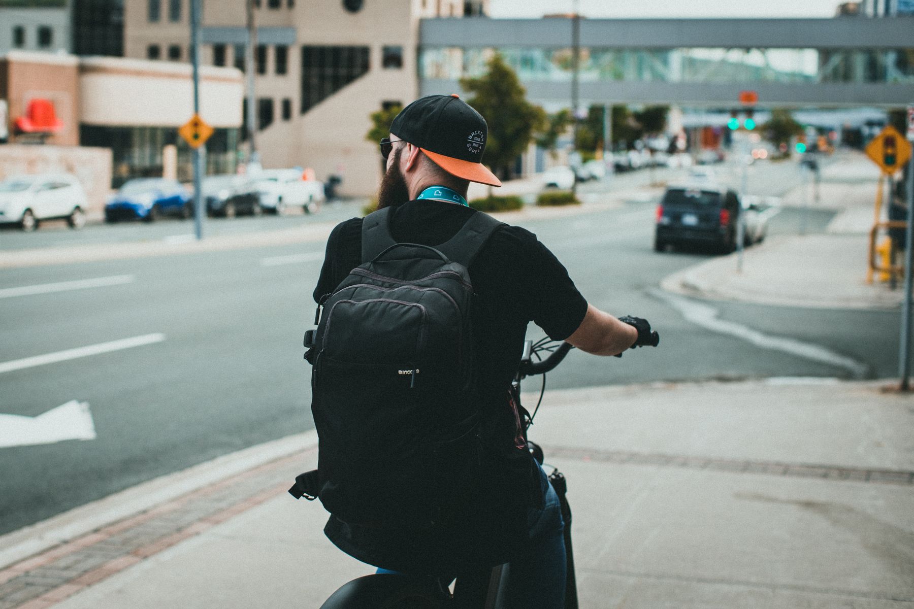 Cyclist with a backpack riding through an urban street