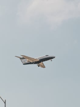 A private jet flying in a clear sky over Los Angeles, showcasing air travel freedom.