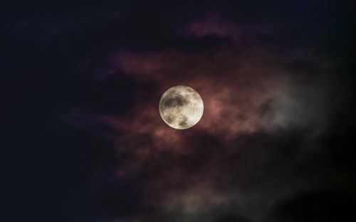Free A captivating full moon with clouds partially covering the night sky, creating a mysterious atmosphere. Stock Photo
