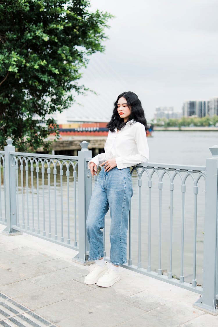 Woman Standing By Barrier In City