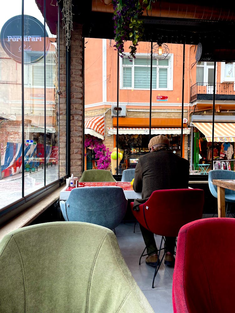 Person In Brown Coat Sitting Alone Inside A Restaurant