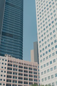 Low angle view of sleek skyscrapers showcasing modern architecture against a clear sky.