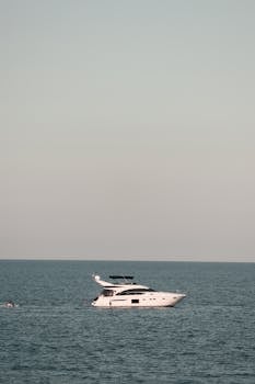 Elegant yacht cruising on the serene ocean under a clear sky, perfect for travel and leisure.