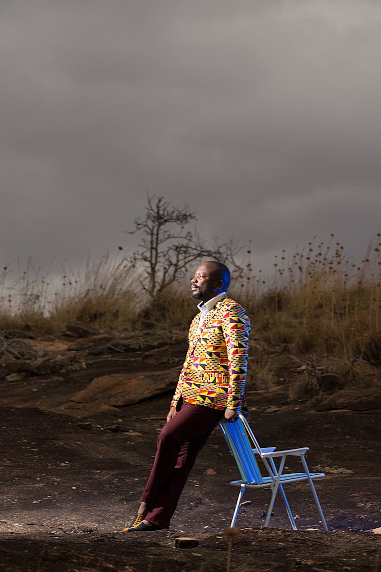 Stylish Man Standing Near Chair In Wild Nature