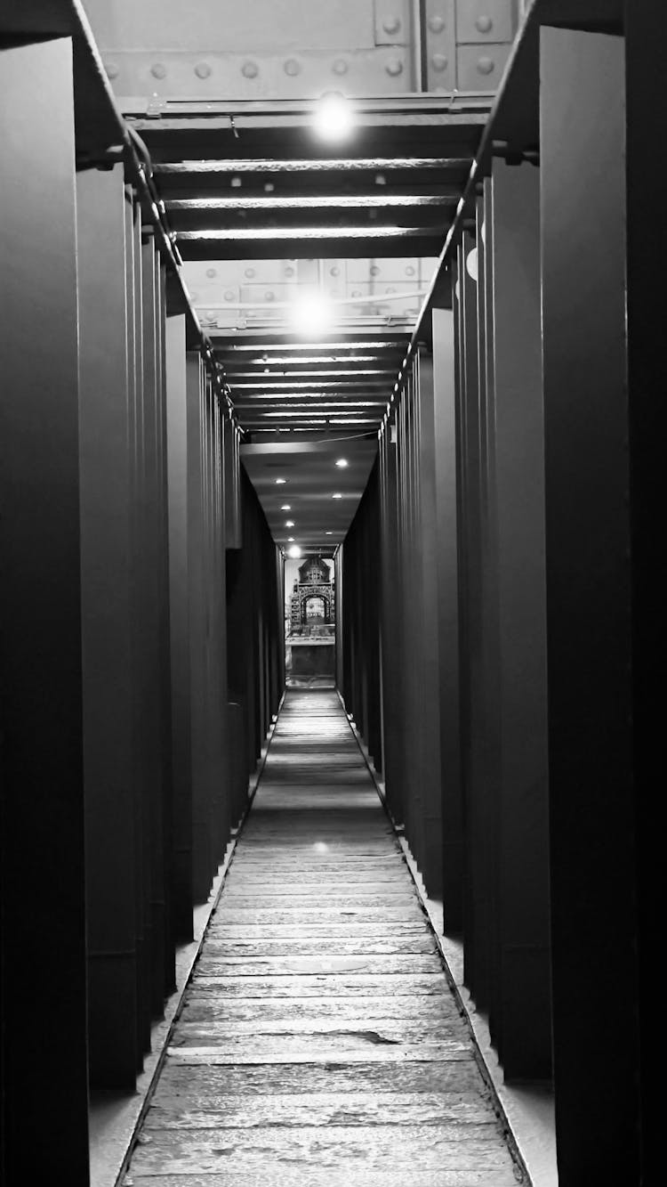 A Grayscale Photo Of An Empty Hallway