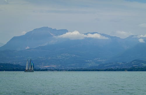 A Sailing Boat on the Sea Near the Mountain