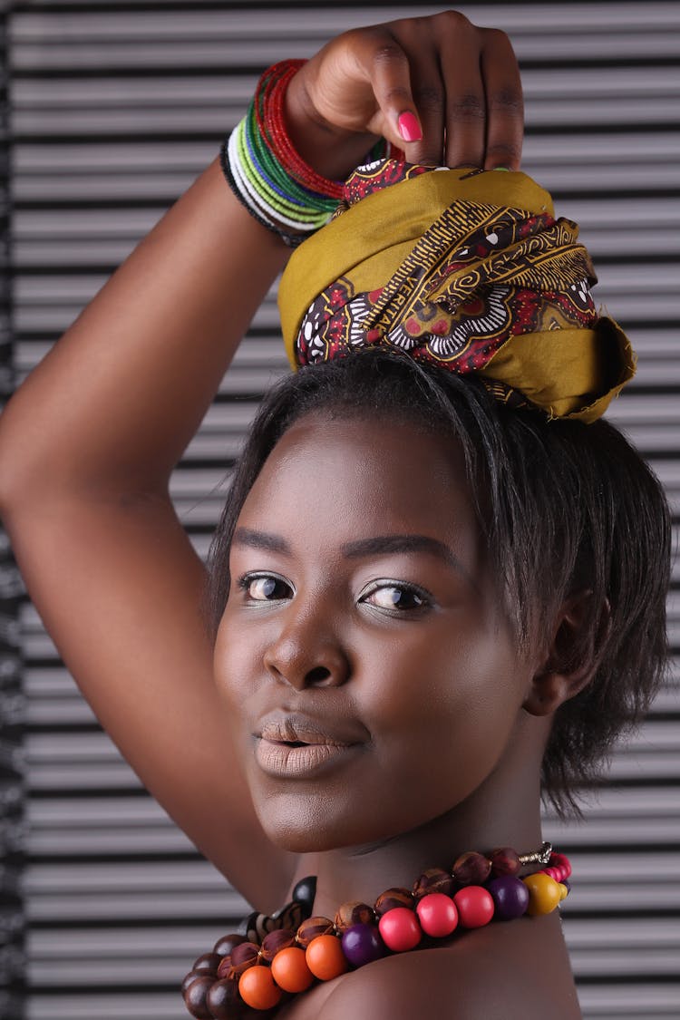 Photo Of A Woman With Mouth Open Holding Folded Scarf On Head