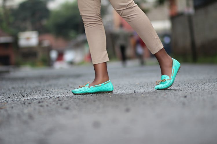 Person In Brown Pants And Green Shoes Walking On Concrete Floor