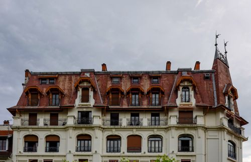 Free Elegant European building with a classic Mansard roof, showcasing architectural detail and charm. Stock Photo
