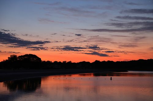 Free Capture the serene beauty of Stamford's lake at sunset, where calm waters meet vibrant skies. Stock Photo