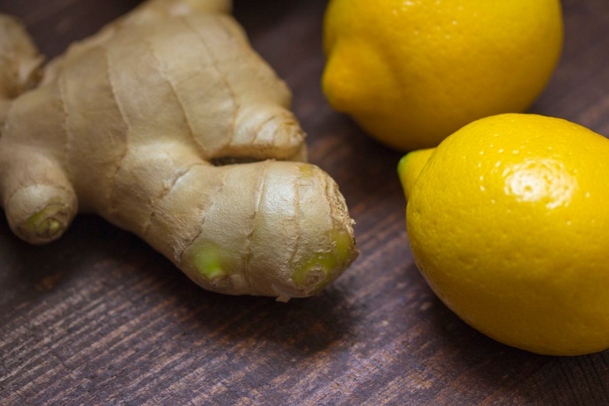 Fresh ginger root and lemons on a wooden surface, traditional natural remedies
