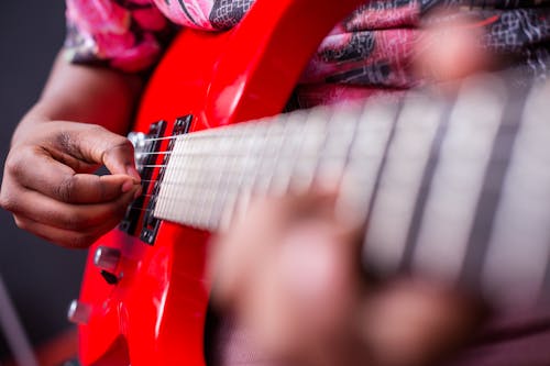 Free A Person Playing a Red Guitar Stock Photo