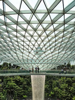 Stunning view of the Rain Vortex at Jewel Changi Airport, showcasing modern architecture with a glass and steel dome.