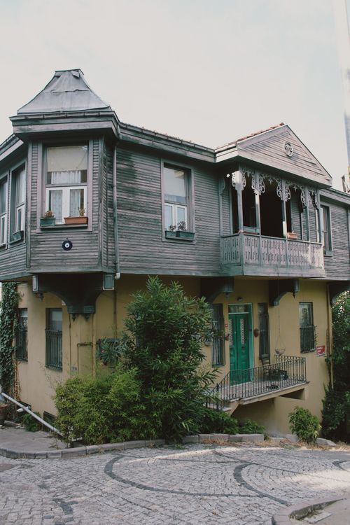 Free Charming historic wooden house with ornate balcony in urban setting, perfect for architecture enthusiasts. Stock Photo