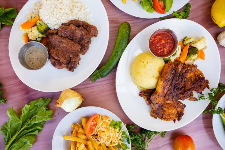 Tasty Meat Dishes On Plates On Table