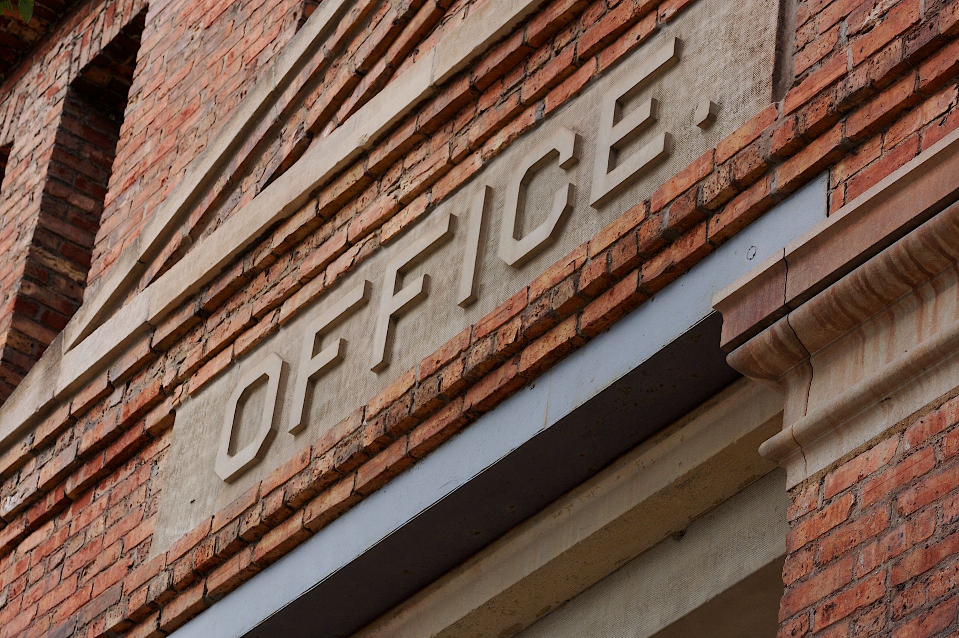 Detailed view of a neoclassical office building facade in Milwaukee with 'OFFICE' engraved.