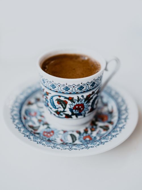 Free An ornate coffee cup with intricate blue and red patterns on a matching saucer. Stock Photo