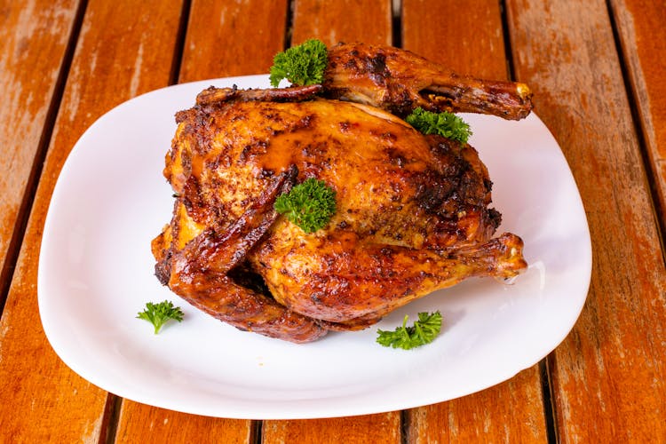 Baked Chicken On Plate On Wooden Table