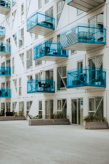 Stylish apartment exterior featuring blue glass balconies and contemporary design.