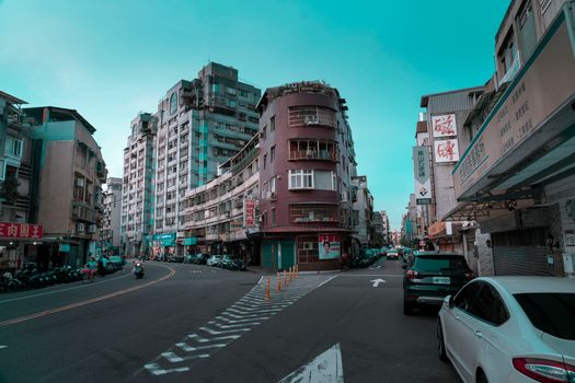 A vibrant city street scene featuring tall buildings, vehicles, and pedestrian activity.