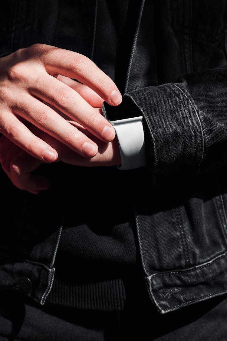 Person In Black Denim Jacket Wearing Gray Apple Watch 