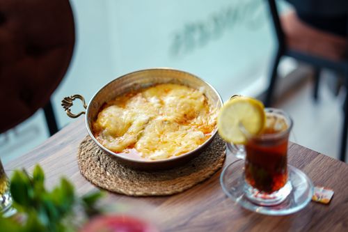 Free Savor a classic Turkish breakfast dish served with lemon tea in a cozy setting. Stock Photo