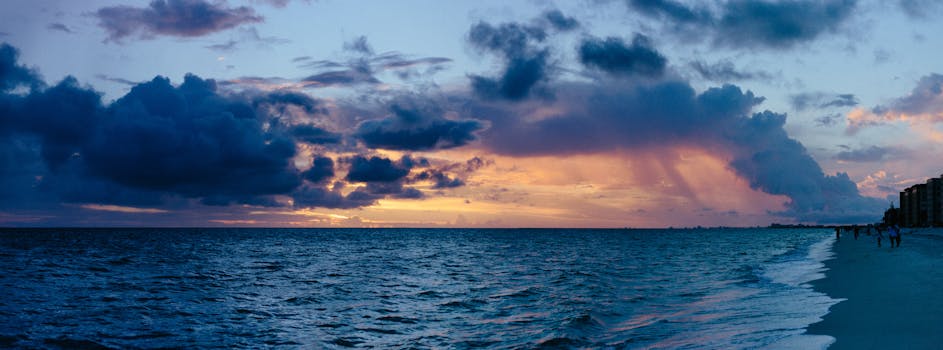 海洋与沙滩上空，充满活力的云和温柔的海浪映衬着一个令人叹为观止的日落