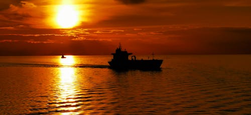 Silhouette of Boat on Sea during Sunset