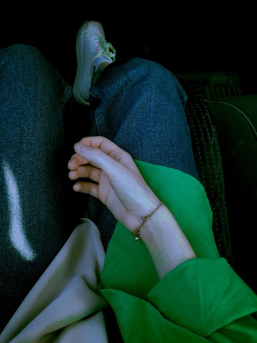 Free A relaxed overhead view of denim jeans paired with a green shirt and bracelet, perfect for casual fashion vibes. Stock Photo