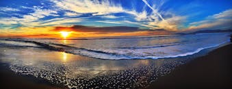 在充满活力的日落景色中，海浪拍打着沙滩